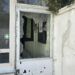 Zerbrochenes Fenster in einer alten Schützenhalle mit Kerben und unordentlicher Umgebung.